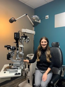 An Optometrist sitting beside an eye machine J